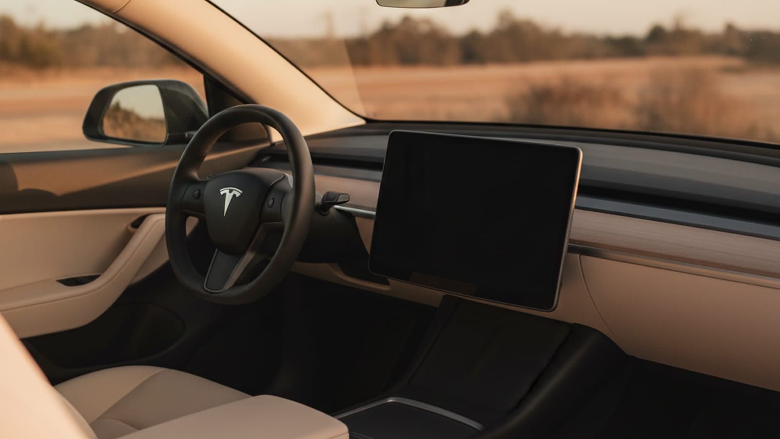 A Tesla Model 3 with the hood open showing the 12V battery location under the frunk panel.